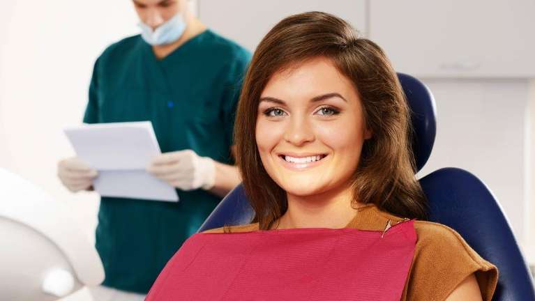 Patient smiling after getting dental crowns from Pradera Dental