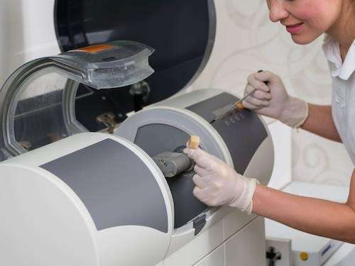 Dentist using a CEREC machine to create crowns in veneers at Pradera Dental