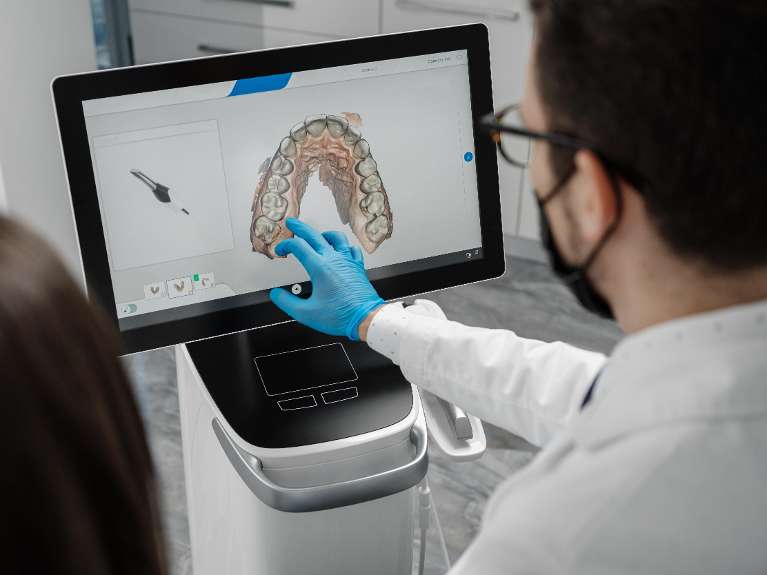 Dentist examining patients teeth using latest digital technology at Pradera Dental