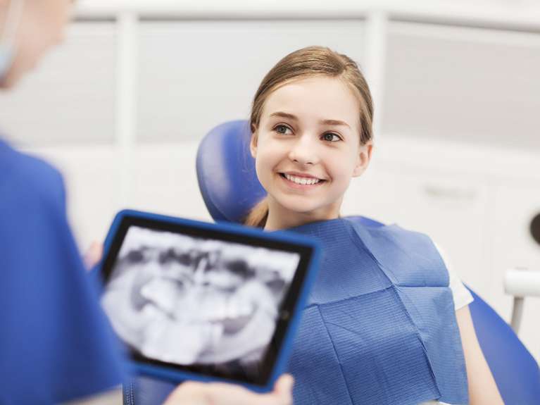 Dentist examining patient's teeth using digital X-ray sensors at Pradera Dental